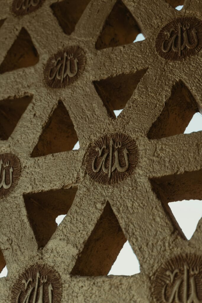 Intricate Islamic geometric design with Arabic calligraphy on a textured wall.